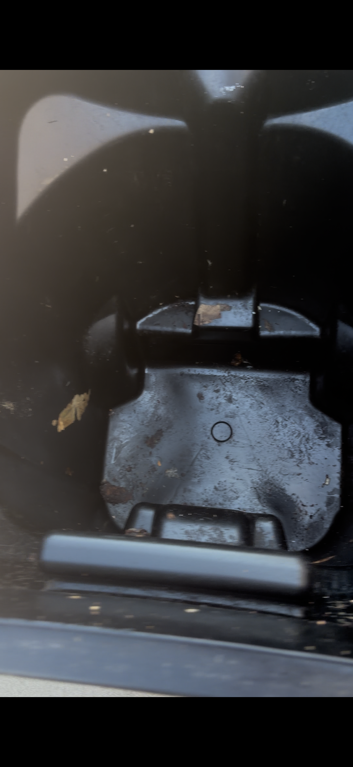 A black trash bin with visible grime and residue on the interior walls and base before cleaning.